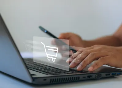 Ein Mensch kauft online am Laptop ein