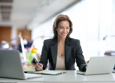 Eine junge Frau arbeitet im Büro an einem Laptop